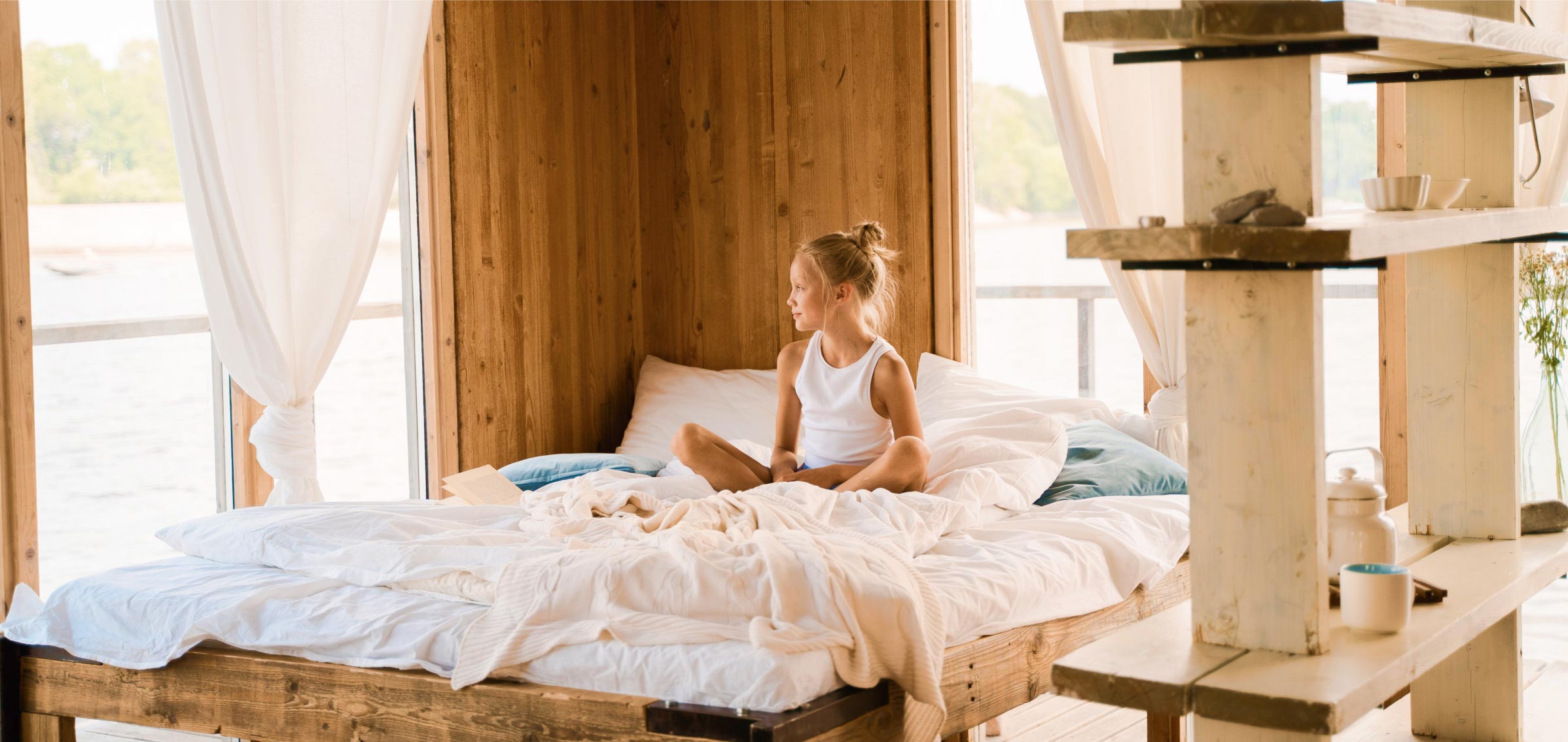 Girl Sitting on Bed Looking through Window Girl Sitting on Bed Looking through Window
